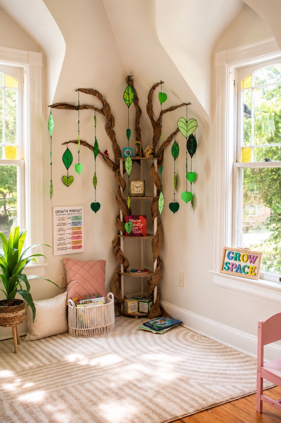 The paper tree in the corner, close up, with leaves and hearts hanging from braided branches.
